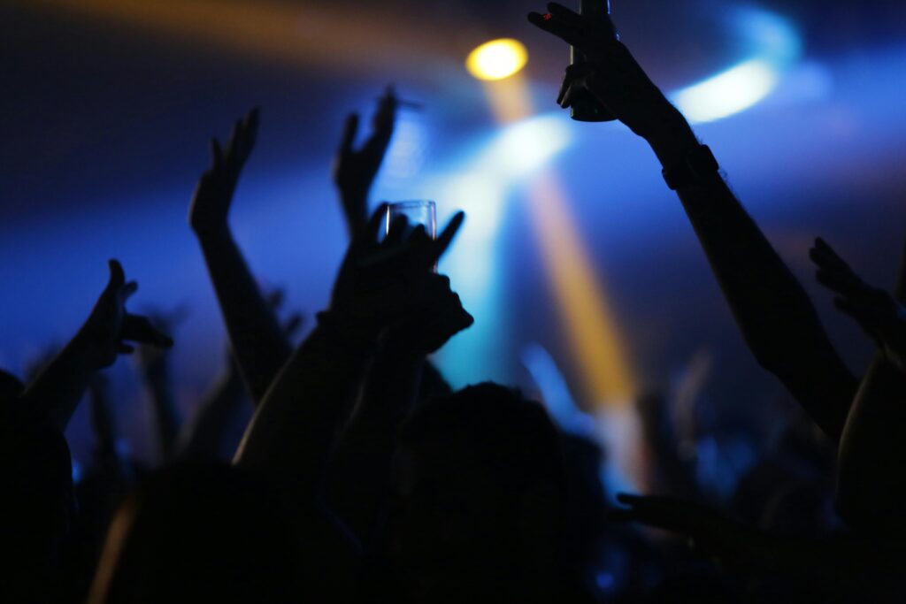A lively nightclub scene with a crowd raising their hands, creating a vibrant nightlife atmosphere.